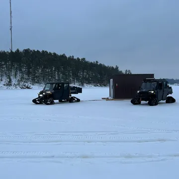 Vehicles parked out on a frozen, snow-covered lake